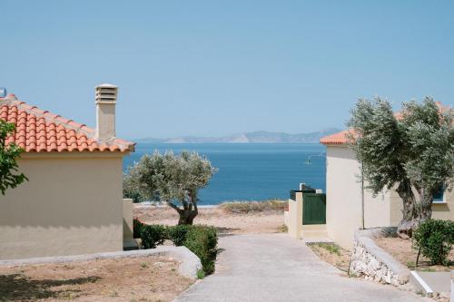 a path between two buildings with a view of the ocean at Mandilada Village in Samos in Marathokampos