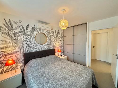 une chambre avec un lit et une peinture murale dans l'établissement Appartement 26 les terrasses de l'isolella Porticcio, à Porticcio