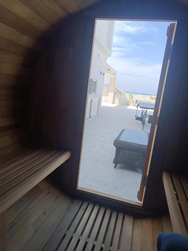 a door to a balcony with a view of a patio at Blue Aura Beach villa Larnaca in Pervolia