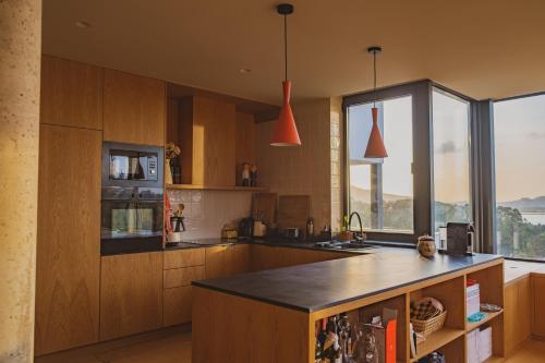 a kitchen with wooden cabinets and a counter top at Casa do Outeiro in Lanhelas