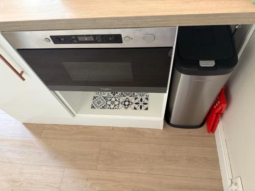 un comptoir de cuisine avec une cuisinière et une poubelle dans l'établissement Appart cosy - terrasse - clim - piscine, à Roquebrune-sur Argens