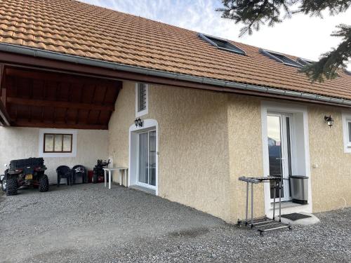 a house with a table and a motorcycle parked next to it at Gîte Belle Vue 2 in Saint-Léger-les-Mélèzes