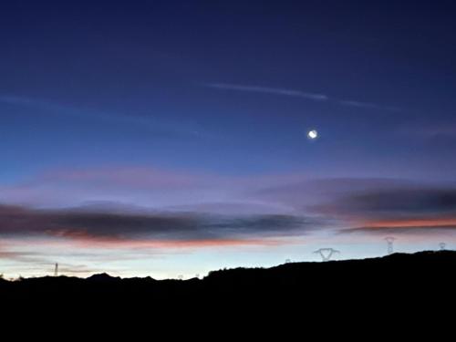 a sunset with the moon in the sky at Gîte Belle Vue 2 in Saint-Léger-les-Mélèzes
