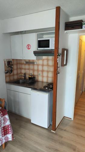 une cuisine avec une cuisinière et un micro-ondes dans l'établissement Studio Contamines-Montjoie, aux Contamines-Montjoie