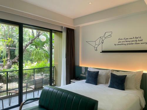 a bedroom with a bed and a large window at TREX Buriram Boutique Hotel in Buriram