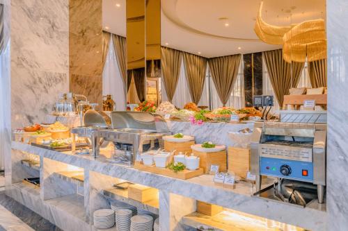 a buffet line with food on display in a restaurant at New Century Dalat Hotel in Da Lat