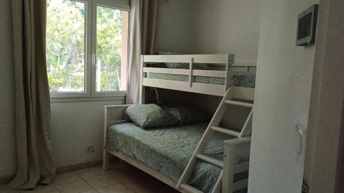 Ce lit superposé se trouve dans un dortoir doté d'une fenêtre. dans l'établissement Un écrin de calme envoutant !, à Andernos-les-Bains