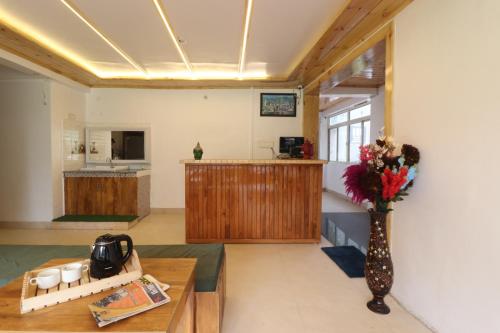a living room with a vase of flowers on a table at Hotel Green Oak in Nainital