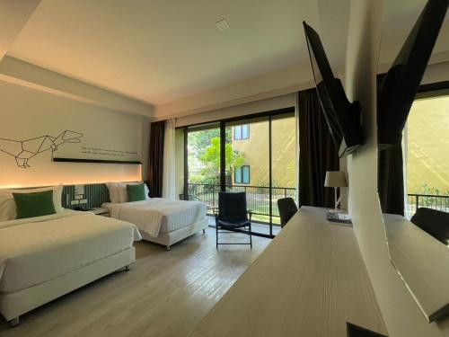 a hotel room with two beds and a balcony at TREX Buriram Boutique Hotel in Buriram