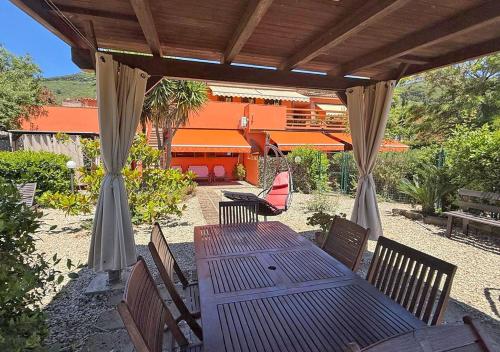 a wooden table and chairs under a pergola at Casa Katia, Giuliana & Nami in Lacona