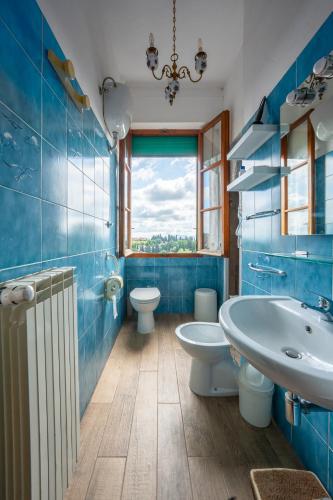 a blue bathroom with two toilets and a sink at Casa nel Borgo Toscano- Casole d'Elsa in Casole dʼElsa