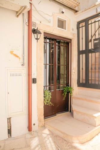 a door of a building with two potted plants at Meta di Puglia - Almalusa Apulian Home by In Puglia service in Martina Franca