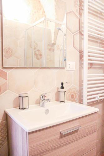 a bathroom with a sink and a mirror at Meta di Puglia - Almalusa Apulian Home by In Puglia service in Martina Franca
