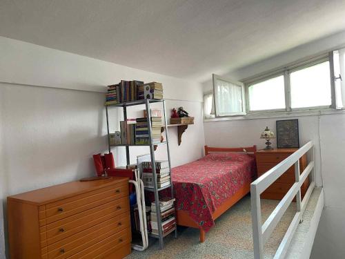 a bedroom with a bed and a book shelf with books at Casa Santa Agua in Ammouliani