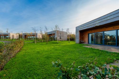 a house with a green yard in front of it at Cosy Cabin Getaway - Ashbourne in Ashbourne