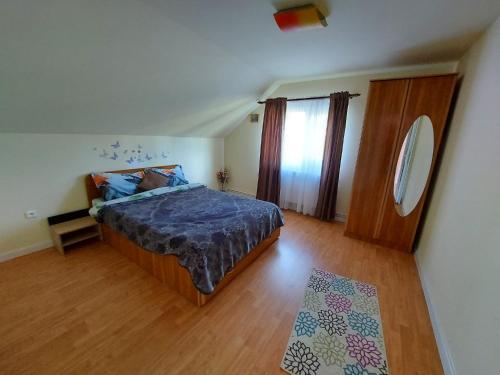a bedroom with a bed and a wooden floor at Casa din Padure Valea Doftanei in Trăisteni