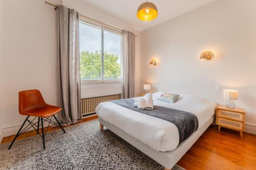 une chambre avec un lit, une chaise et une fenêtre dans l'établissement Le Prestige - Au cœur de Nantes, à Nantes