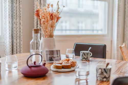 une table avec des beignets, des verres et une bouteille dans l'établissement Le Prestige - Au cœur de Nantes, à Nantes