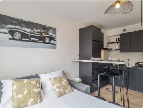 une chambre avec un lit et une cuisine avec une voiture sur le mur dans l'établissement Appartement t2 pour 4 avec parking, à Tasdon