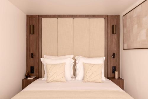 une chambre avec un grand lit avec des oreillers blancs dans l'établissement chic A C central apt - 2bdr 6p - faubourg s denis, à Paris