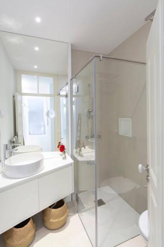 a white bathroom with a sink and a shower at Luxury Historic House with Private Jacuzzi in Lagos