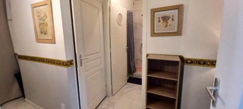 a bathroom with a walk in shower and a white door at Appartement avec jardin et spa in Valras-Plage