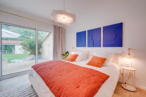 a bedroom with a large bed and a large window at Le Clos Saint Jean in Tizac-de-Curton