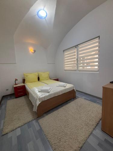 a bedroom with a bed with yellow pillows and a window at Apartament central zone in Sibiu