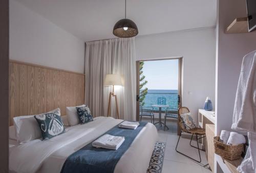 a bedroom with a bed and a view of the ocean at Enorme Serenity Spritz - Adults Only in Hersonissos