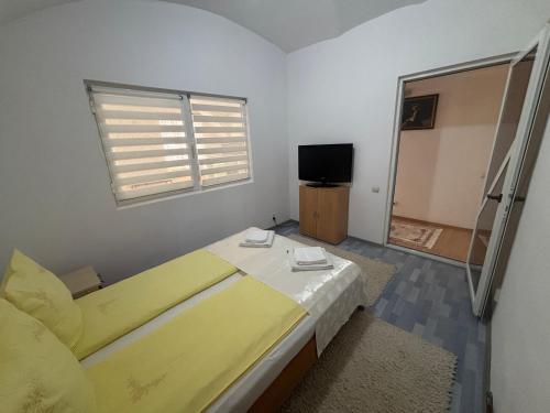 sypialnia z żółtym łóżkiem i telewizorem w obiekcie Apartament central zone w Sybinie