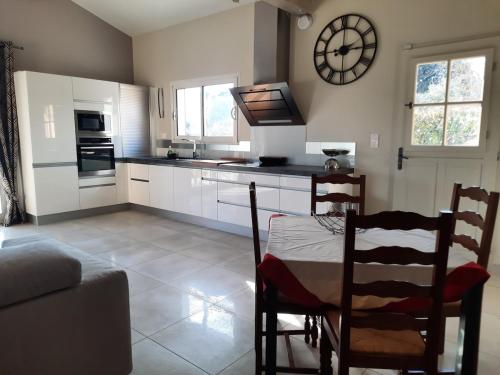 une cuisine avec une table et une horloge au mur dans l'établissement Maison en Provence, à Jouques
