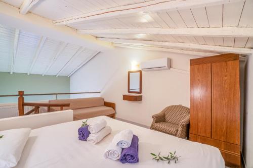 a room with a bed and a couch and a chair at Corfu Club Apartments in Corfu