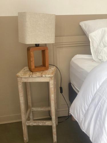 une chambre avec un lit et une table avec une lampe dans l'établissement L'Antre, à Villequier