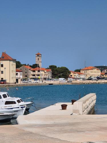 a boat is docked at a dock in the water at Apartments Valentina Tisno in Tisno
