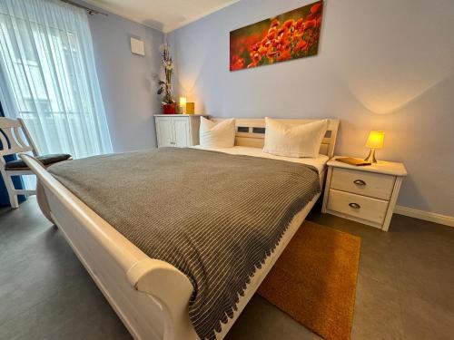 a bedroom with a large bed and a lamp on a table at Aquamarin Ostseetraumsuite 01 in Neuhaus