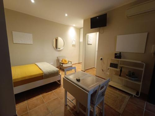 a room with a bed and a table and a mirror at La Coccola in Santa Maria delle Mole