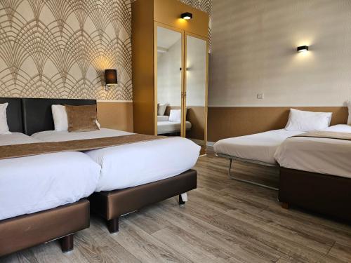 a hotel room with two beds and a mirror at ATN Hôtel in Paris