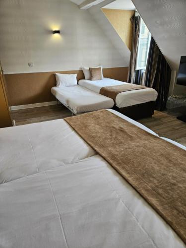 a hotel room with two beds and a rug at ATN Hôtel in Paris
