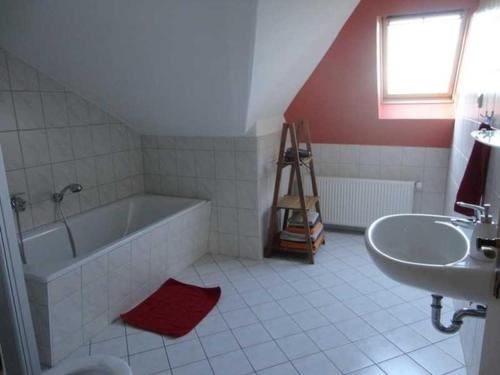 a bathroom with a bath tub and a sink at Ferienwohnung im Stadtpark in Neubrandenburg