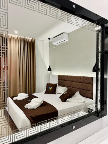 a bedroom with two beds and a large mirror at Relax Apts Saranda in Sarandë