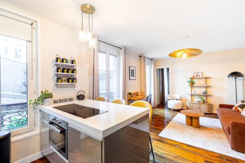 - une cuisine avec un îlot blanc dans le salon dans l'établissement Chambre au calme près du Père-Lachaise, à Paris