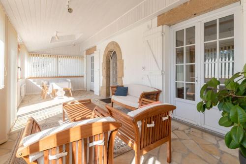 - une terrasse couverte avec des chaises et une table dans l'établissement Maison ensoleillée et conviviale, à Lancieux