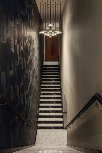 a hallway with a staircase with a chandelier at London Marriott Hotel Grosvenor Square in London