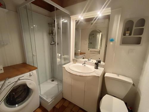 une salle de bain avec un lavabo, des toilettes et une douche dans l'établissement maison mitoyenne dans residence de vacances, à Soulac-sur-Mer
