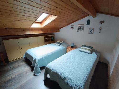Cette chambre mansardée comprend 2 lits et une lucarne. dans l'établissement maison mitoyenne dans residence de vacances, à Soulac-sur-Mer