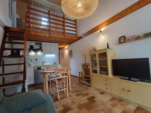 Il comprend un salon avec une télévision et une cuisine. dans l'établissement maison mitoyenne dans residence de vacances, à Soulac-sur-Mer