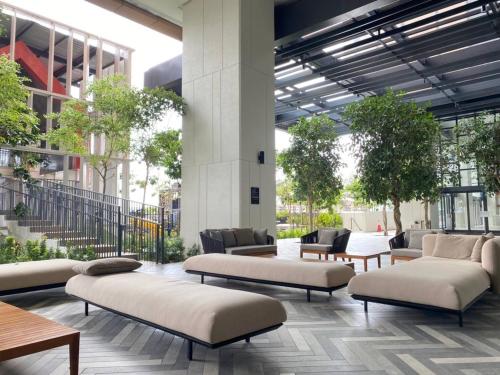 a lobby with couches and tables in a building at 1BR condo with Amazing KLCC View & Infinity Pool at Lalaport Bukit Bintang in Kuala Lumpur