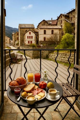 een dienblad met ontbijtproducten op een tafel op een balkon bij Hotel Restaurant Le Col de Crous in Péone