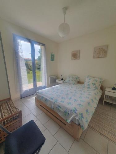 a bedroom with a bed and a large window at maison residence les arros in Soulac-sur-Mer