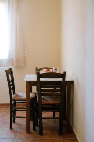 a dining room table with two chairs and a table and a table and chairsktop at Mandilada Village in Samos in Marathokampos